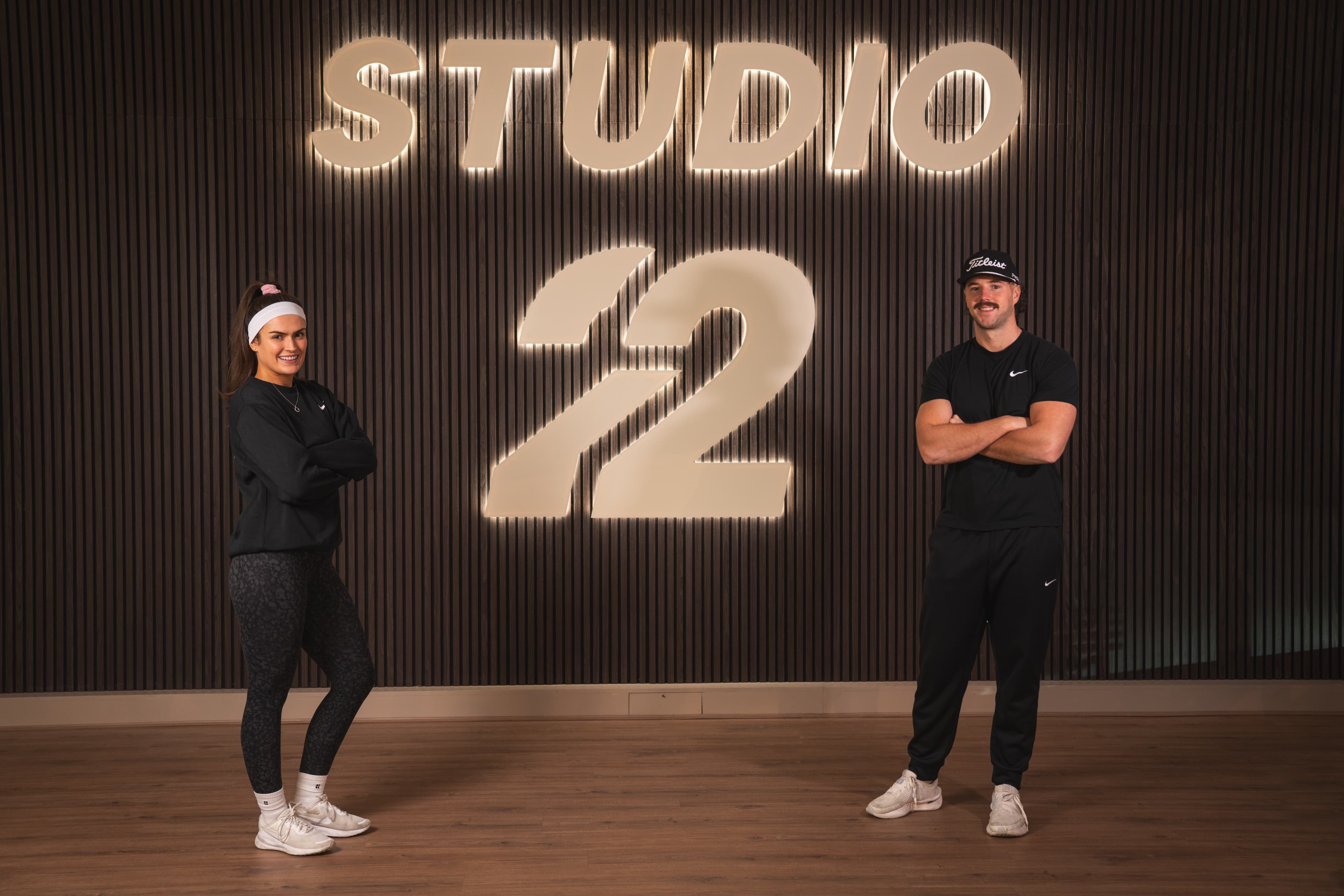 The Studio 22 founders beneath the backlit Studio 22 sign